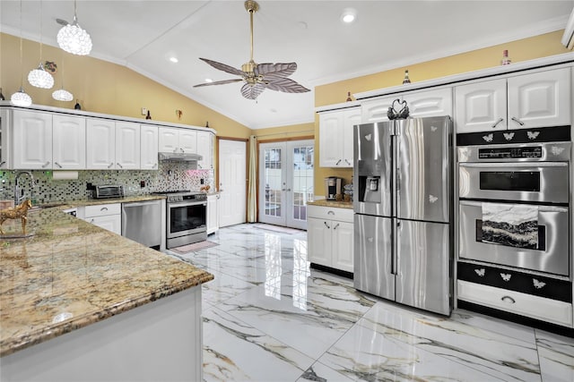 kitchen featuring lofted ceiling, stainless steel appliances, decorative backsplash, and white cabinetry