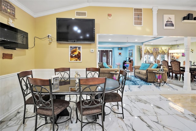 dining area featuring lofted ceiling, ornamental molding, and ornate columns