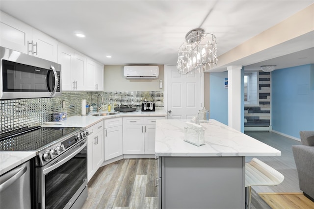 kitchen with stainless steel appliances, tasteful backsplash, decorative light fixtures, white cabinets, and sink