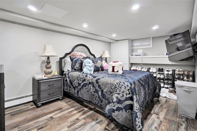 bedroom with hardwood / wood-style floors and a baseboard radiator