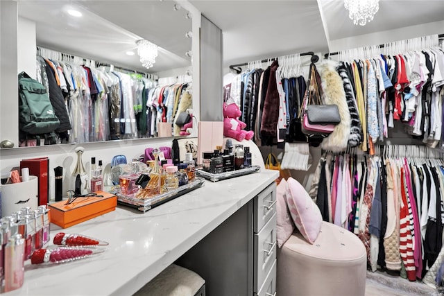 spacious closet featuring an inviting chandelier