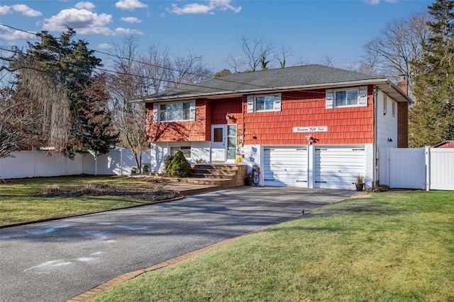 split foyer home featuring a front lawn and a garage