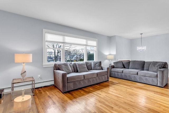 living room featuring a baseboard heating unit, an inviting chandelier, and light hardwood / wood-style floors