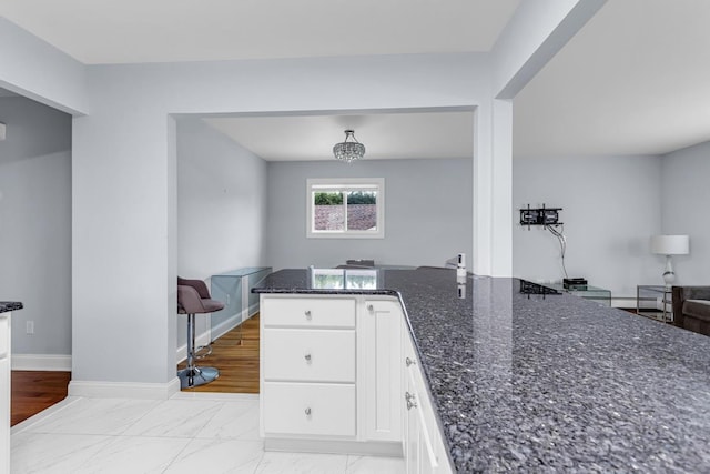 kitchen featuring white cabinets and dark stone counters