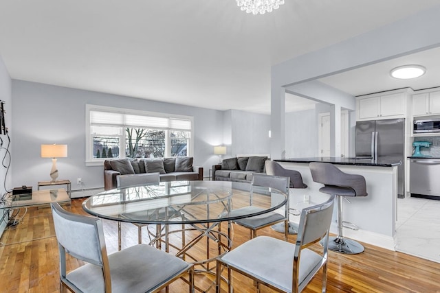 dining room with a baseboard radiator and a chandelier