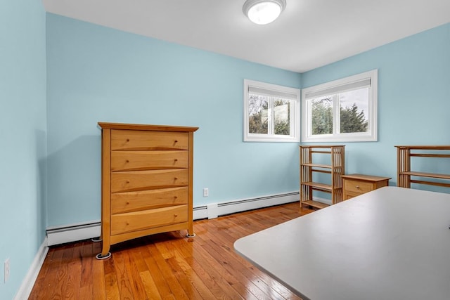 bedroom featuring light wood-type flooring and a baseboard radiator