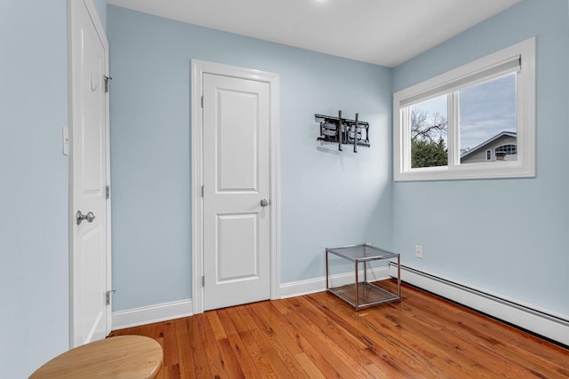 interior space featuring baseboard heating and light hardwood / wood-style flooring