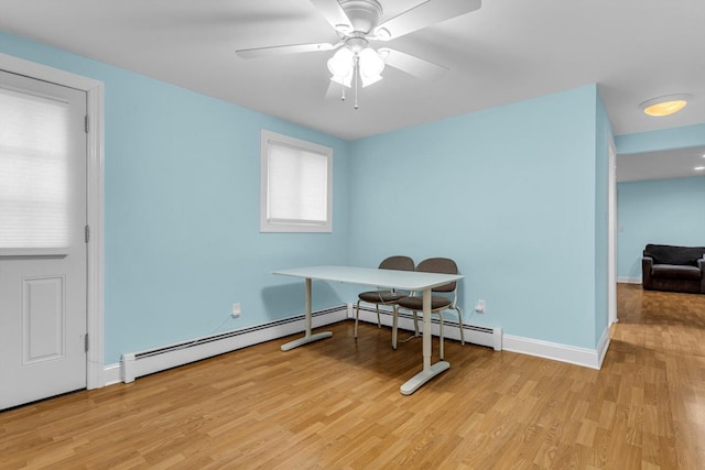 office space with ceiling fan, light hardwood / wood-style flooring, and a baseboard heating unit