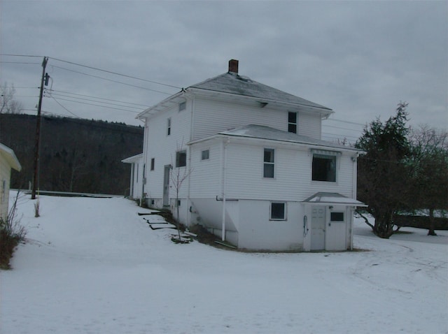 view of snow covered back of property