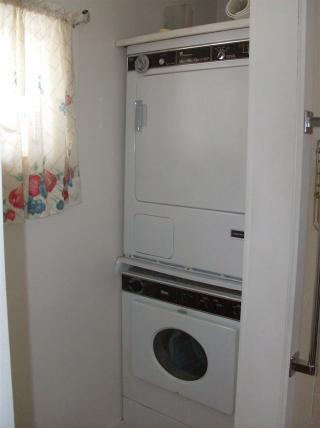 clothes washing area with stacked washer and dryer