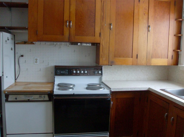 kitchen with white dishwasher, electric range oven, sink, and decorative backsplash