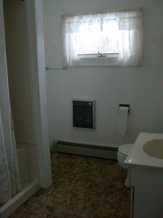 bathroom featuring toilet, vanity, a baseboard heating unit, and walk in shower