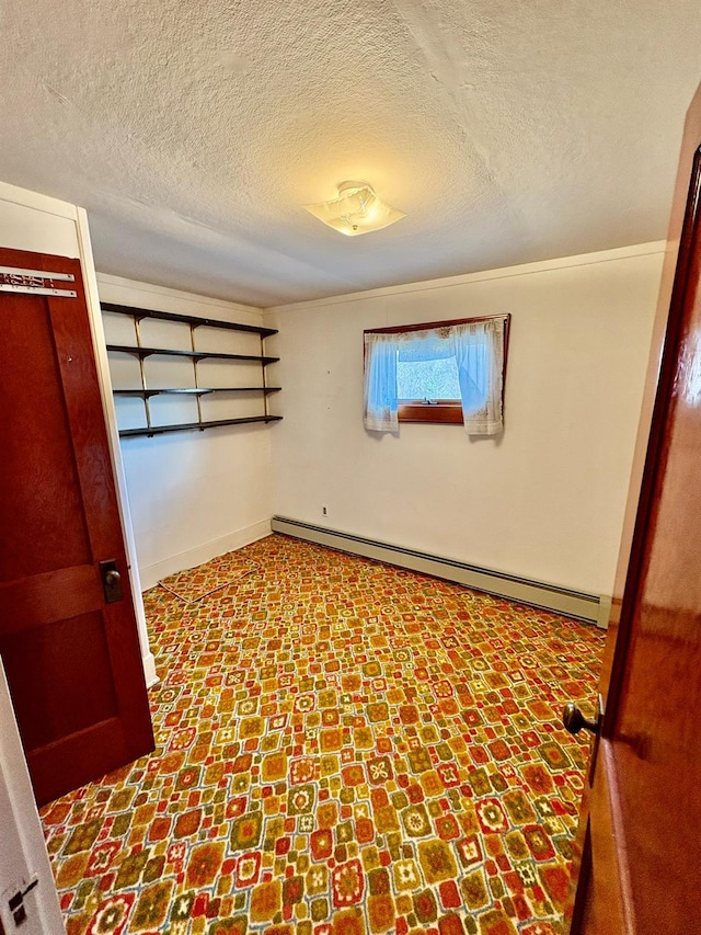 23 Riverside Dr, Roscoe, NY 12776 - unfurnished bedroom with baseboards, a textured ceiling, and a baseboard radiator