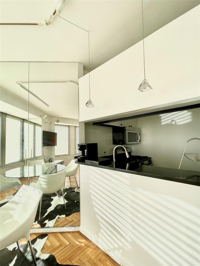 kitchen with gas range oven, pendant lighting, and parquet floors