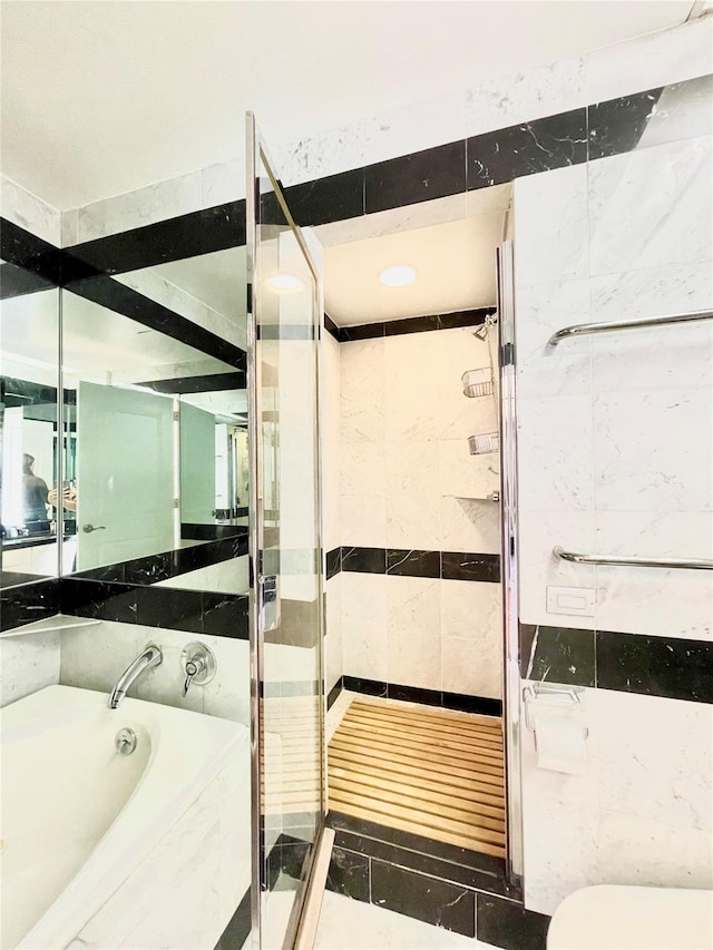 bathroom featuring tile walls, tile patterned floors, and shower with separate bathtub