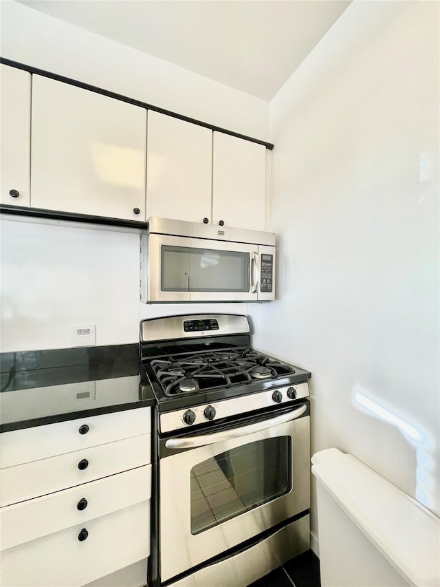 kitchen with stainless steel appliances, white cabinets, and tile patterned floors