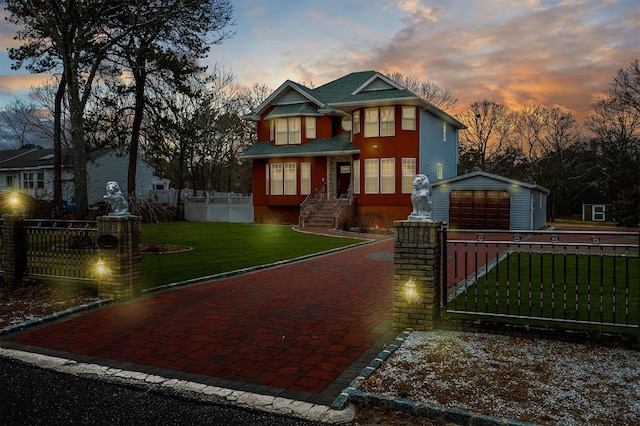 view of front of house featuring decorative driveway, a fenced front yard, a front yard, and an outdoor structure