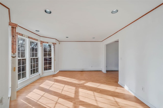 empty room featuring a baseboard radiator, ornamental molding, and wood finished floors