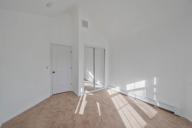 empty room with high vaulted ceiling, a baseboard radiator, visible vents, and carpet flooring