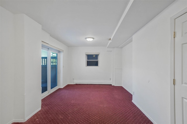 carpeted empty room featuring a baseboard radiator and baseboards