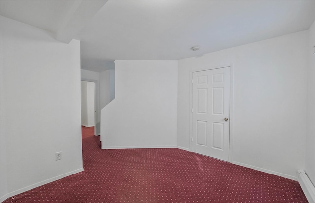 spare room featuring carpet floors, a baseboard radiator, and baseboards