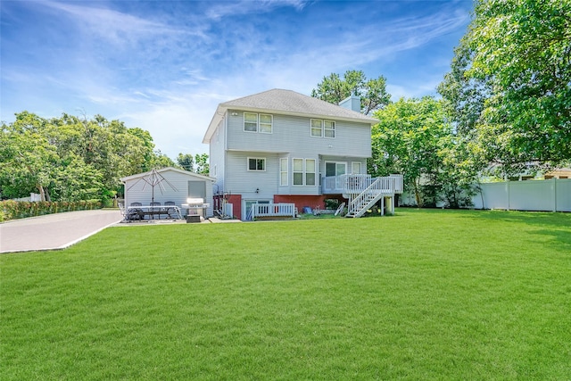 back of house with stairway, fence, a lawn, and a wooden deck