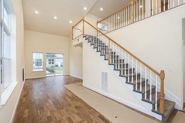 stairs featuring wood-type flooring and a towering ceiling