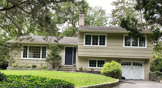 split level home featuring a front yard and a garage