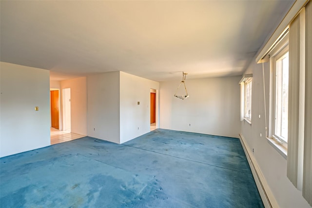 carpeted empty room with a baseboard heating unit and a wealth of natural light