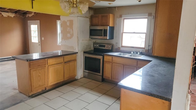 kitchen featuring sink, kitchen peninsula, appliances with stainless steel finishes, and plenty of natural light