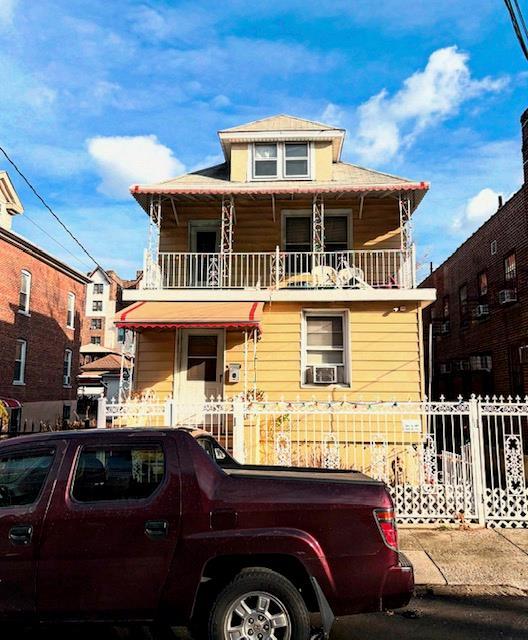 view of front of property with cooling unit and a balcony