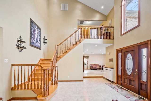 tiled entrance foyer featuring high vaulted ceiling