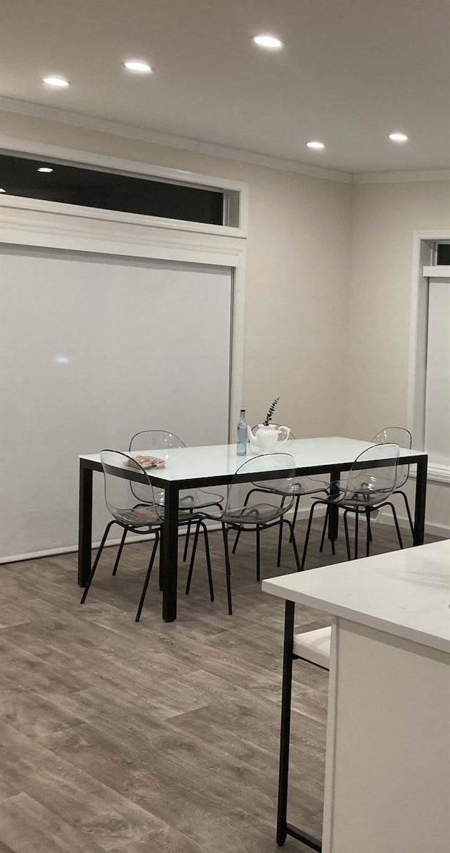 dining area featuring dark wood-type flooring and crown molding