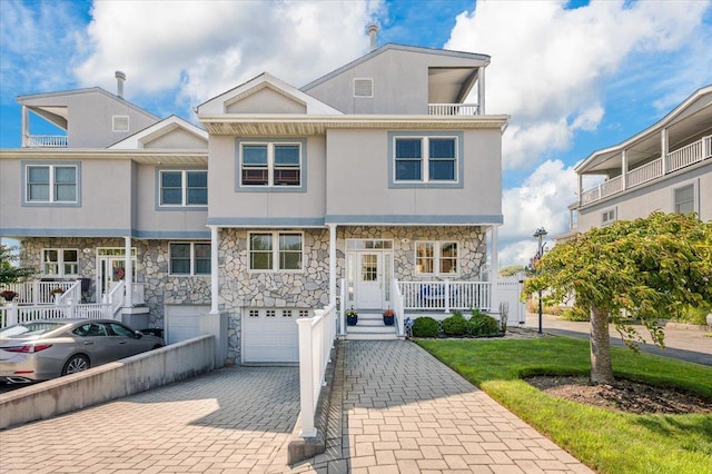 view of property with a porch and a garage