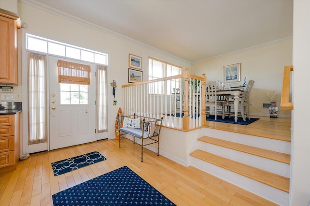 entryway with crown molding, light hardwood / wood-style floors, and plenty of natural light