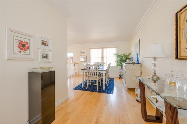 dining area with light wood-type flooring and crown molding