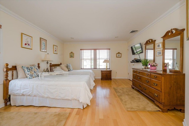 bedroom featuring ornamental molding and light hardwood / wood-style flooring