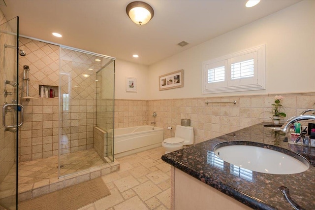 full bathroom with toilet, shower with separate bathtub, tile walls, and vanity