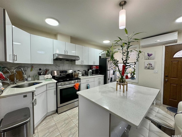 kitchen with sink, white cabinets, hanging light fixtures, and appliances with stainless steel finishes