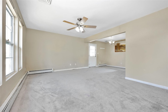 carpeted spare room featuring a wealth of natural light, baseboards, and a baseboard radiator