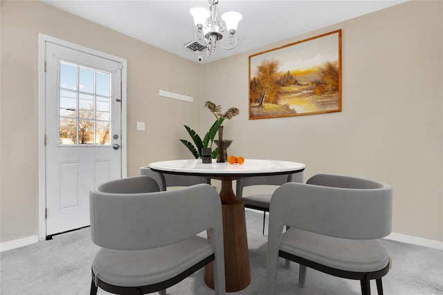 carpeted dining area featuring a notable chandelier, visible vents, and baseboards