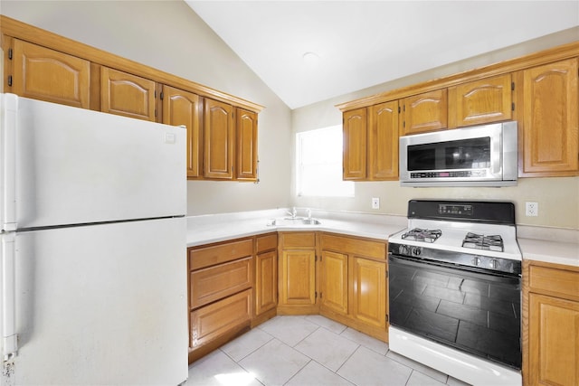 kitchen featuring a sink, white appliances, light countertops, light tile patterned floors, and lofted ceiling