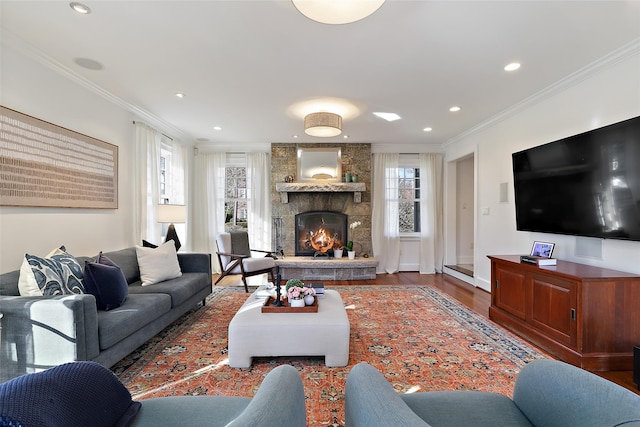 living room featuring a fireplace, ornamental molding, and wood-type flooring