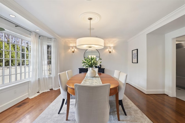 dining area with ornamental molding, a wealth of natural light, and dark hardwood / wood-style floors