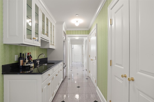 interior space featuring sink, white cabinets, and ornamental molding