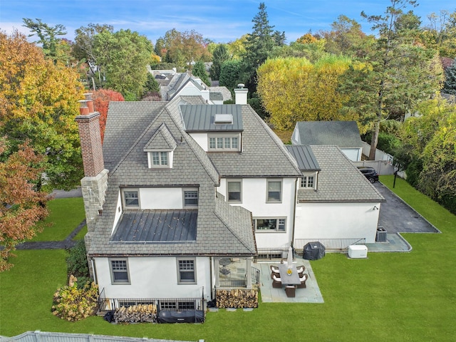 back of property with a yard, an outdoor hangout area, and a patio area