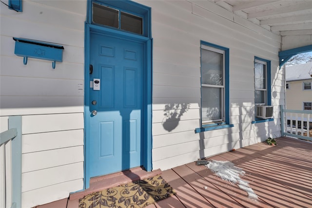 view of exterior entry featuring covered porch and cooling unit