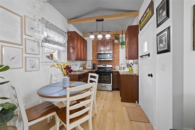 kitchen with light hardwood / wood-style flooring, decorative light fixtures, sink, vaulted ceiling with beams, and stainless steel appliances