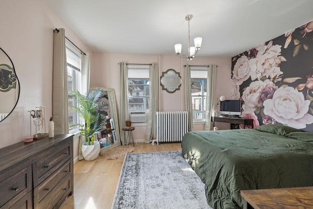 bedroom with cooling unit, radiator heating unit, a chandelier, and light wood-type flooring