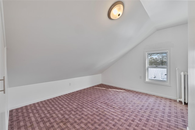 bonus room featuring radiator heating unit, carpet floors, and lofted ceiling